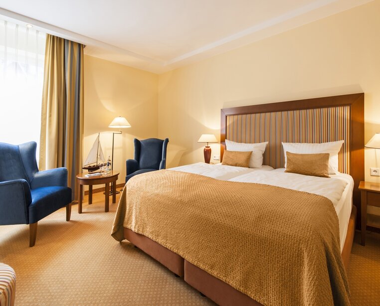 Comfortably furnished room in a classical, light-flooded style with air-conditioning and a cozy sitting area in the 4-star hotel Ringhotel Birke in Kiel | © Ringhotel Birke in Kiel