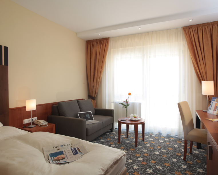 Wohnbereich mit Couch zum gemütlichen fernsehen im Superior Einzelzimmer 4 Sterne Hotel Ringhotel Bundschu in Bad Mergentheim | © Ringhotel Bundschu in Bad Mergentheim