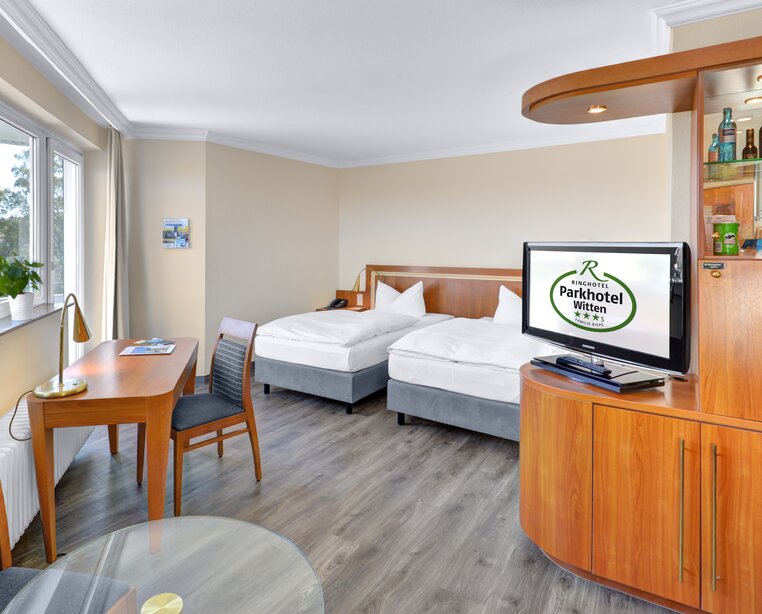 Spacious business rooms with table, armchair and TV at the 3-star-superior hotel Ringhotel Parkhotel Witten in Witten | © Ringhotel Parkhotel Witten