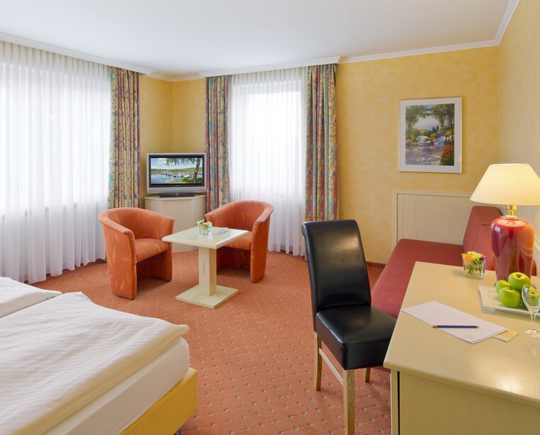 Zimmer mit Schreibtisch und großem Sitzbereich im 4 Sterne Hotel Ringhotel Roggenland in Waldeck | © Ringhotel Roggenland in Waldeck