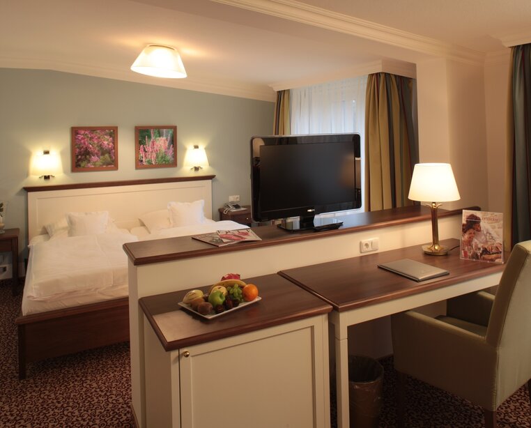 Zimmer mit gemütlicher Sitzecke, optisch vom Schlafbereich getrennt im 4 Sterne Hotel Ringhotel Sellhorn in Hanstedt | © Ringhotel Sellhorn in Hanstedt