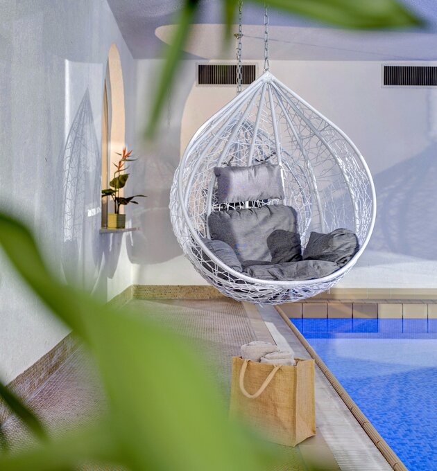 Innenpoolbereich mit Hängesesseln und entspannter Atmosphäre im Ringhotel Sonnenhof in Baiersbronn, einem 4-Sterne-Hotel im Schwarzwald. | © Ringhotels Sonnenhof in Baiersbronn