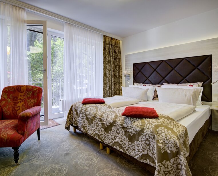 Elegantes Doppelzimmer mit Balkonzugang und Blick ins Grüne im Ringhotel Sonnenhof in Baiersbronn, einem 4-Sterne-Hotel im Schwarzwald. | © Ringhotel Sonnenhof in Baiersbronn